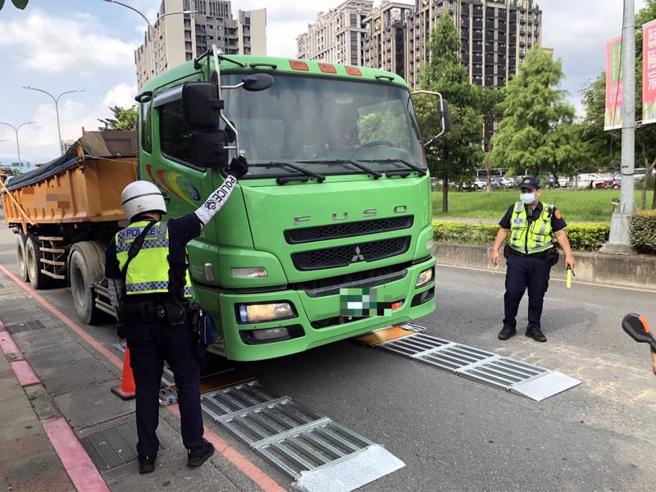 道路工程載重有其上限，新北市板橋警分局13日下午2時至6時在板橋區板城路新北果菜市場前，以活動地磅執行取締砂石大貨車超載勤務；科技執法沒有模糊空間，活動地磅一測量就知道。（圖/ 中央社）