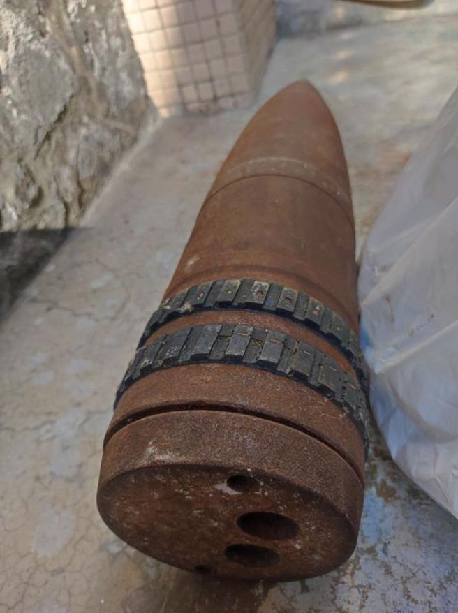 高雄袁姓妇人在家中打扫找到一颗重约6公斤、外观锈蚀圆柱体炮弹，军方到场初判为空壳无火药，已带回处理。（图/ 中央社）