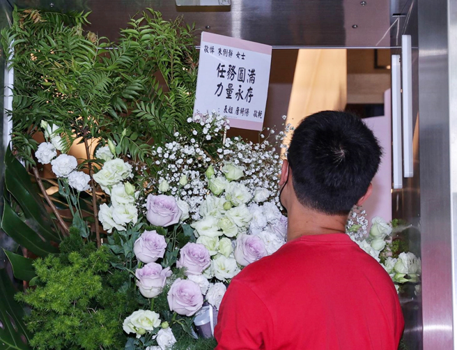 唐绮阳在花篮上的花牌写下「任务圆满、力量永存」致哀。（图／罗永铭摄）