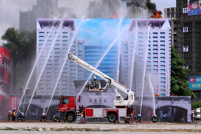 「全民防卫动员暨灾害防救（民安8号）演习」14日在新北市泰山塭仔圳重划区举行，实兵演练模拟大台北地区遭遇6级强震袭击，板桥车站大楼起火燃烧，警消到场疏散民眾并射水灭火。（黄世麒摄）
