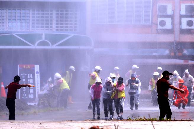 「全民防卫动员暨灾害防救（民安8号）演习」14日在新北市泰山塭仔圳重划区举行，实兵演练模拟大台北山区遭致灾性暴雨袭击，多处发生土石流，居民在警消引导下撤离住所，演练相当逼真。（黄世麒摄）