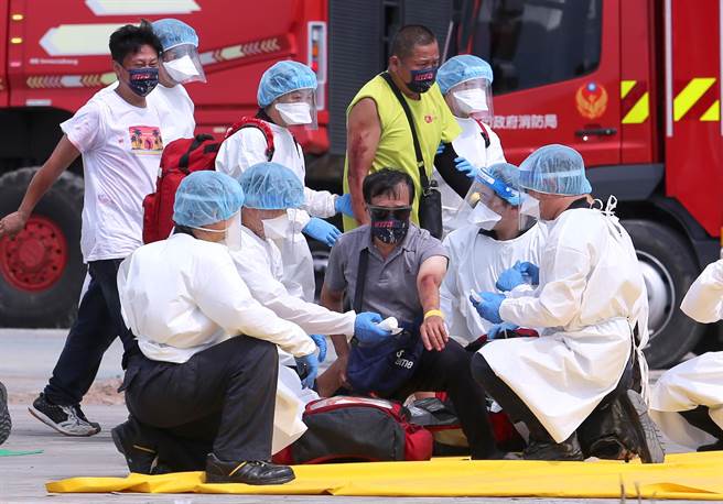 「全民防卫动员暨灾害防救（民安8号）演习」14日在新北市泰山塭仔圳重划区举行，实兵演练模拟飞机失事，救护人员在现场设立检伤区救治病患。（黄世麒摄）