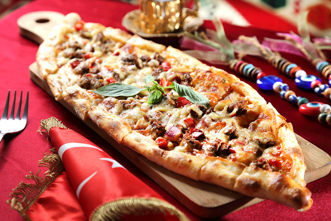 「起司牛肉比嗲」為土耳其版披薩，一入口即感受強烈的香料衝擊，餅皮越嚼越香，邪惡的牽絲起司讓人無法拒絕。(攝影/Carter)