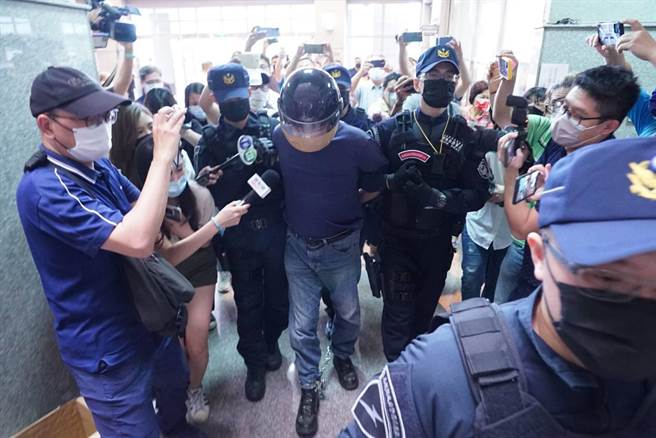 李男3點53分在警方戒護下抵達南投縣刑大，被問到為何殺人，李嫌能高喊「為了復仇」、「有深仇大恨」，被問到槍枝如何取得、有沒有接受殺手訓練，他則說是「你給的」（指記者），態度輕蔑，絲毫沒有悔意。（吳建輝攝）