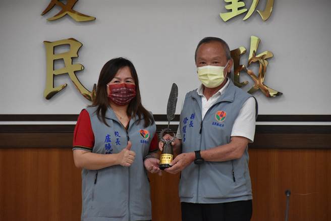 苗栗县泰安乡泰兴国小校长卢晓玲将亚军奖杯献给县长徐耀昌。（谢明俊摄）