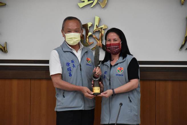苗栗县南庄乡果河国小校长高清菊将亚军奖杯献给县长徐耀昌。（谢明俊摄）