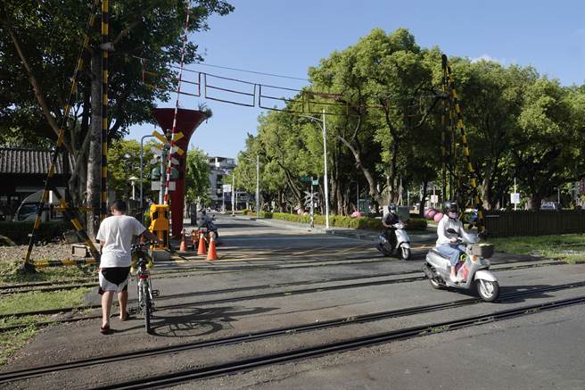 阿里山林铁北门车站旁平交道慢车道升降式遮断机已停用，改用直臂式（红白相间直长杆），原遮断机塔柱设施仍将留在原地。（黄子明摄）