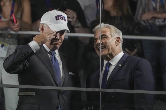 美国总统拜登14日访问以色列，在以色列代总理拉皮德 (右)陪同下前往观赏球赛。拉皮德15日证实，沙乌地已宣布向以国航班开放领空。 (美联社)