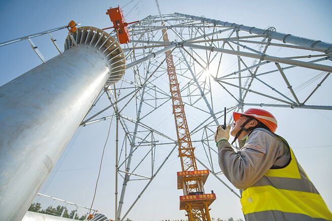 入夏以来，大陆单日发电量快速攀升，统计13日调度发电量达到278.54亿瓩时、最高调度负荷达12.22亿瓩，均创歷史新高。图为安徽送变电工程公司人员进行电塔施工。（新华社）