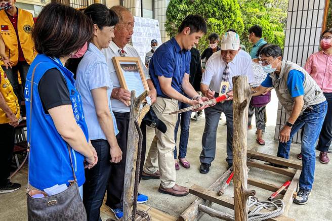 林清治（左三）捐赠的木马和轻便车等给新竹林管处，由地方耆老彭学尧（右二）在文物上题字。（罗浚滨摄）