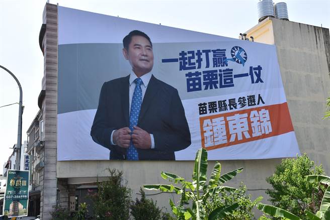 国民党主席朱立伦17日赴苗栗县党部，坚持参选到底的苗栗县议长锺东锦刻意在前一天在党部旁挂上竞选看板。（谢明俊摄）
