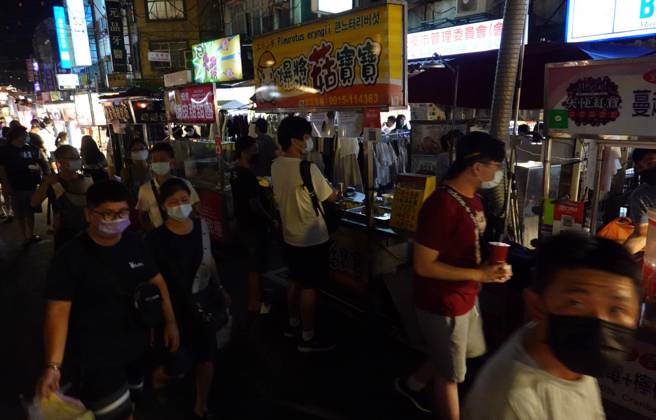 台北市饶河街夜市16日晚间发生停电，店家靠着微弱的灯光做生意，民眾摸黑逛街。（姚志平摄）