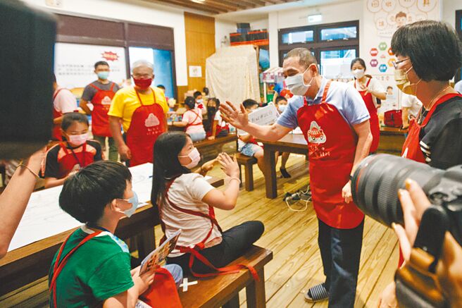 侯友宜、林佳龍雙方競選團隊連日來為林口交流道擴建案、恩恩案隔空互嗆。圖為侯友宜15日到新北玩具銀行「玩聚窩」與學童互動的畫面。（郭吉銓攝）