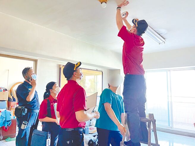 高雄市消防局人员协助将住警器安装于天花板上。（翻摄照片／洪靖宜高雄传真）