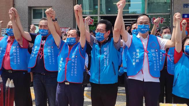 眾人高舉雙手，高喊團結一致要力拚年底選戰。（李京昇攝）