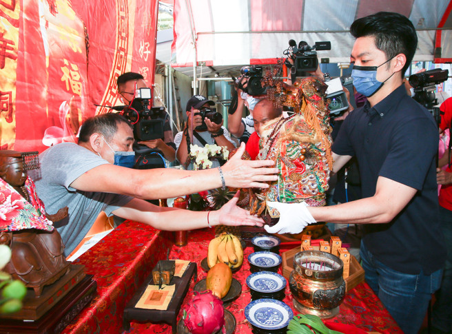 蒋万安（图右）17日出席「恭迎台北安西妈祖会口罩妈祖驻驾吉庆」活动，按照礼俗完成仪式，现场民眾一旁高喊「冻蒜」。（陈俊吉摄）