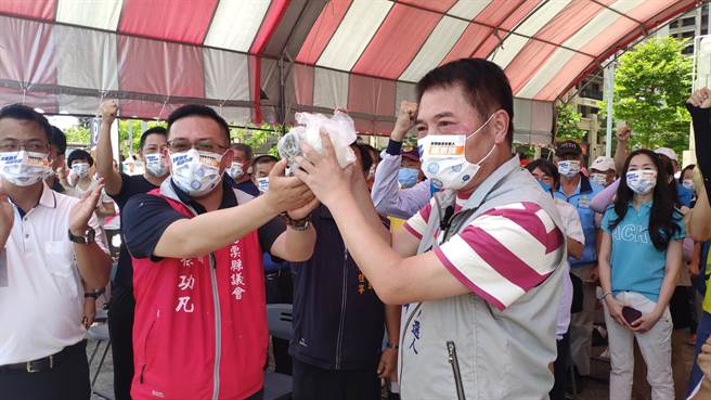 苗栗议长锺东锦接下支持者赠予的包子跟粽子，象徵当选。（李京升摄）