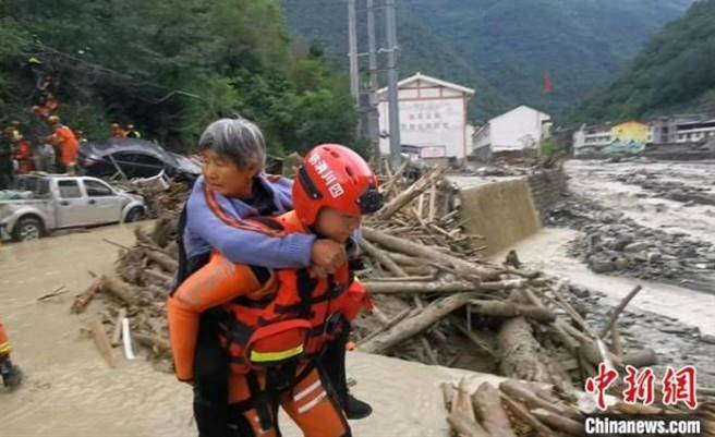 大陆四川绵阳市北川县西部洪灾，已酿6死，12人失联。图为消防人员正在转移受灾群眾。（摘自中新网）