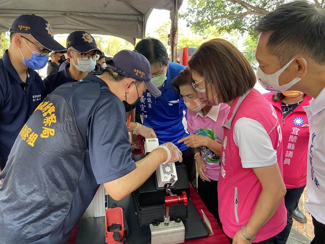 今（17日）下午2时在丢丢噹森林广场，举办「乐舞青春、无毒兰阳」活动，宜兰县长林姿妙听取警察专业解说「潜伏指纹增显暗箱」操作模式，利用不同波长光源，去显现指纹或证件上的防偽标志。（吴佩蓉摄）