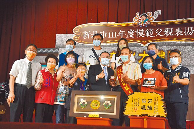 新北市府16日举行今年度模范父亲表扬大会，新北市长侯友宜颁赠金戒指与奖牌，给予54位荣获模范父亲代表。（蔡雯如摄）