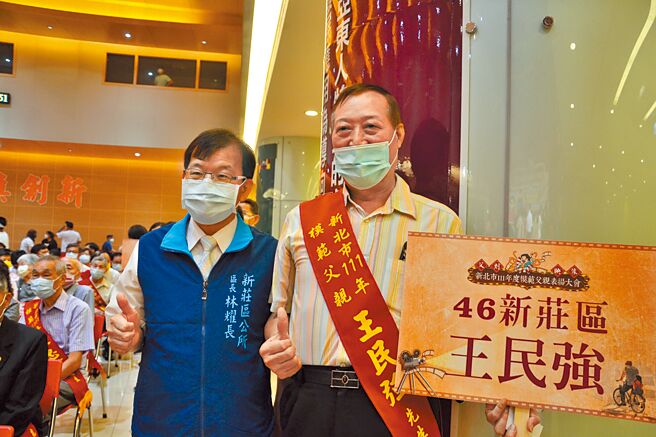 新庄区的模范父亲王民强（右）不畏身障限制，到工地上班，拉拔3位子女，15年来甚至坚持担任志工，奉献精神令大眾感佩。（蔡雯如摄）