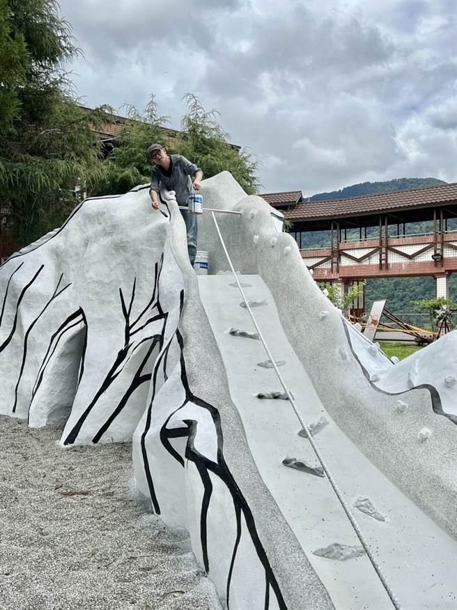 梨山中小学打造独一无二的山林戏场，校长洪永明提着油漆桶协作画上结构。（洪永明提供／陈淑娥台中传真）