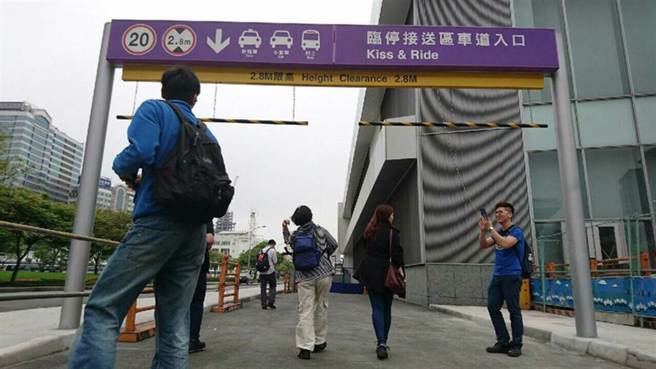 桃园机场捷运线A1站告示牌，写着「Kiss & Ride」（亲一下就走），真正意思是「临时停车接送区」。（图／中央社提供）