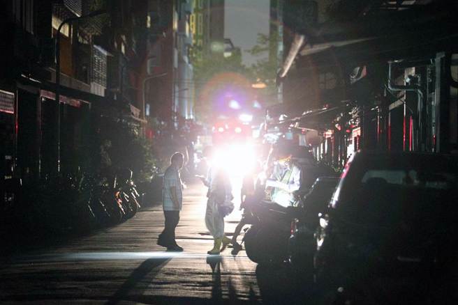 台北市民生东路三段、合江街一带共962户停电，巷道一片漆黑，台电人员戴上头灯，穿梭在各大楼间维修。（黄世麒摄）