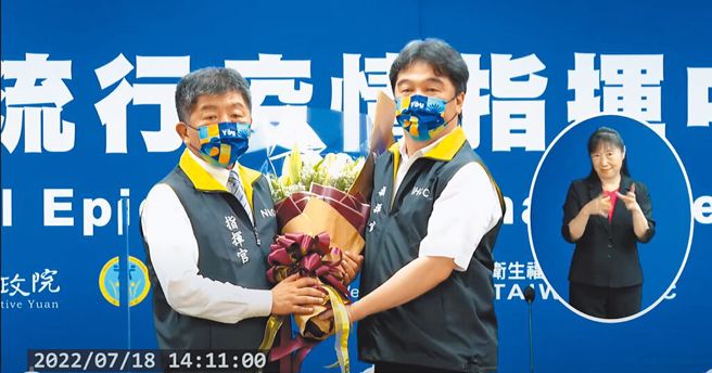 王必勝(右)從陳時中(左)手中接棒指揮官後，隨即送出口罩鬆綁大禮包。（取自中央流行疫情指揮中心直播）