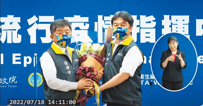 中央流行疫情指挥中心18日举行指挥官交接，陈时中将背心交接给新任指挥官王必胜。（摘自中央流行疫情指挥中心直播）