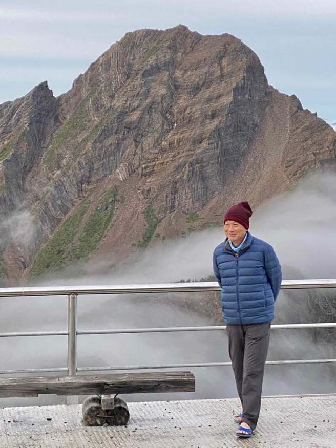 郑明典全身包紧紧和玉山合影，唯独脚上穿着蓝白拖鞋露出脚趾头。（图／FB郑眀典）