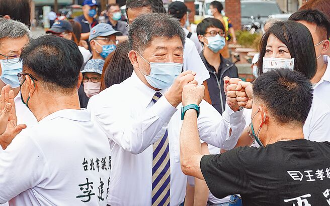 民進黨台北市長參選人陳時中（中）19日前往台北霞海城隍廟上香參拜，並與黨籍市議員參選人擊拳致意。（姚志平攝）