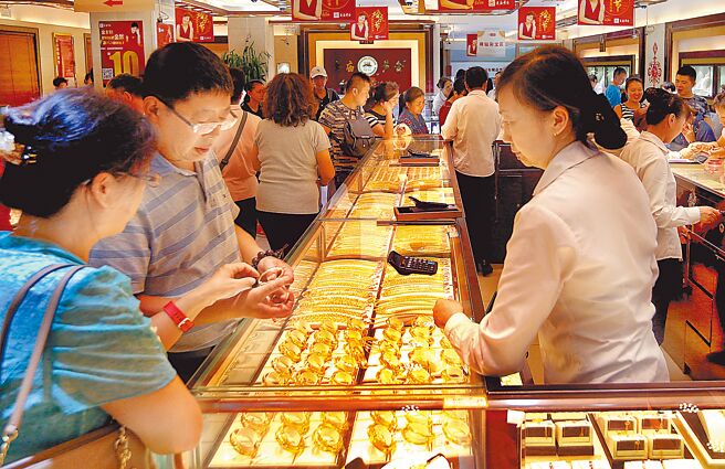 金价跌跌不休，不仅令中国大妈抢进，台湾投资人现在也「分批买进」捡便宜。图为上海民眾选购黄金饰品。（新华社）