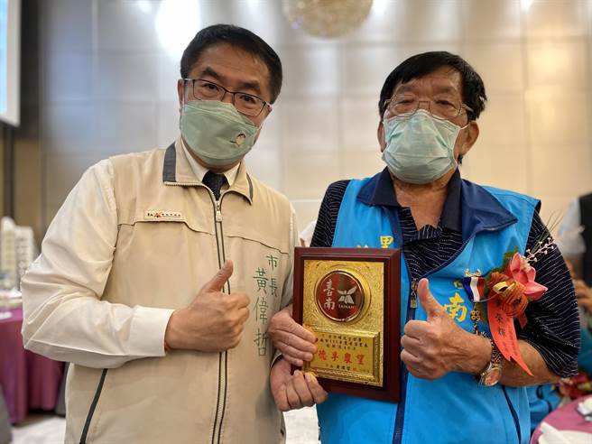 82岁的台南市七股区溪南里长黄荣辉(右)，是台南首位服务超过40年的资深里长。(曹婷婷摄)