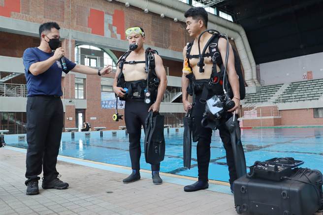 消防局抢救科长王景宾为嘉义县长翁章梁介绍潜水设备和用途。（吕妍庭摄）