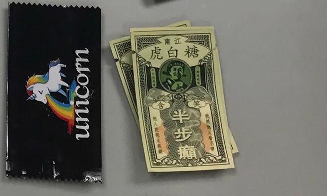 高雄市少年警察队透过网路巡逻查获贩毒集团，特别以知名电影用语「含笑半步癫」、「一日丧命散」等为毒品包取名，吸引年轻人上门。（图/ 中央社）