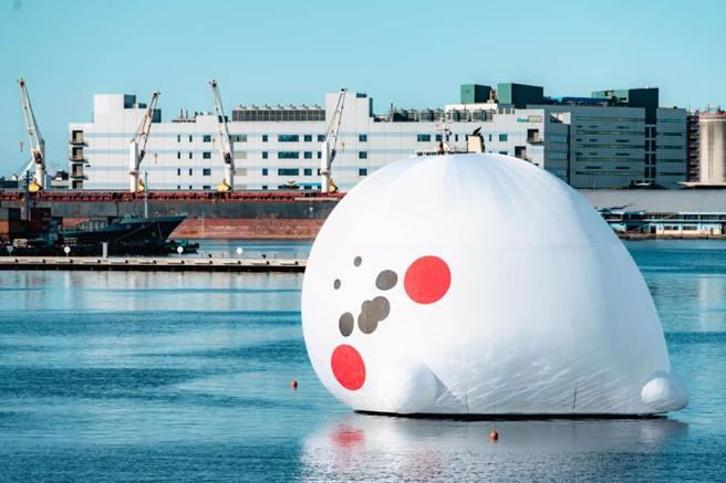 LINE人气贴图「无所事事小海豹」巨型充气装置近期悄悄躺进爱河湾。（图/ 中央社）