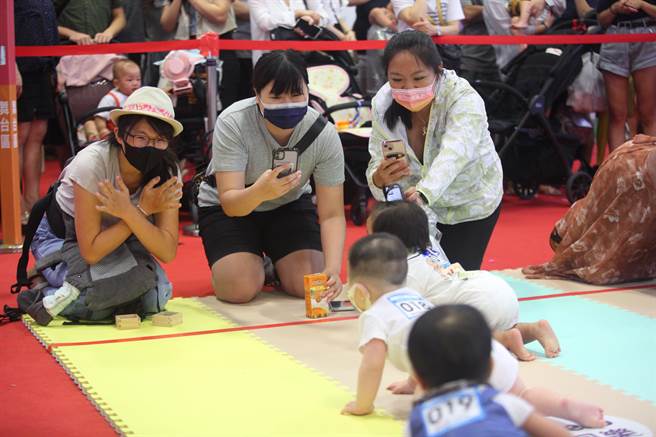 台北国际妇幼用品大展7月22日到25日在台北世贸一馆登场，图为许多家长带着家中宝贝参加大宝宝爬行比赛，并卖力为宝宝加油。（张铠乙摄）
