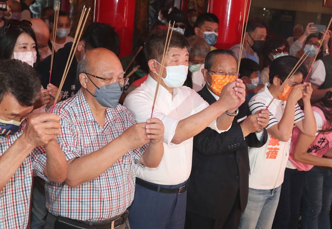 民进党台北市参选人陈时中（中）22日前往松山慈佑宫参香祈福，在地方人士的陪同下，手持香火参拜。（郑任南摄）