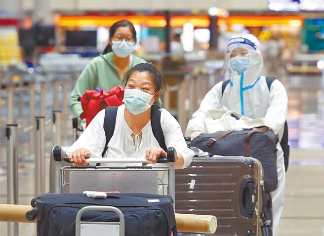 中央流行疫情指挥中心指挥官王必胜22日表示，考量当前国际疫情发展，边境开放时程没有时间表。图为在桃园机场第一航厦入境大厅内，刚下机的旅客正前往採检站採检。（范扬光摄）