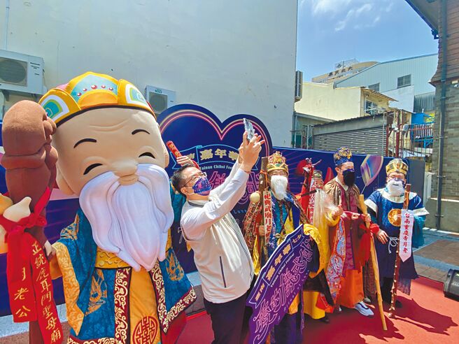 市长黄伟哲宣传七夕嘉年华，现场俏皮地与台南7大月老庙的月老们自拍。（曹婷婷摄）