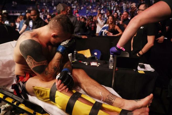 UFC拳手艾斯平纳膝盖受伤，被担架送出场。（路透）