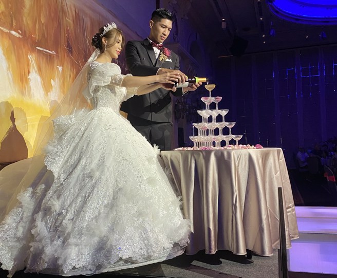 周柏臣与老婆一起完成香槟塔。(黄及人摄)