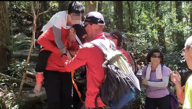 顏姓女登山客右脚踝受伤，搜救人员给予包扎固定后，以背负方式下撤登山口。（台中市消防局提供）
