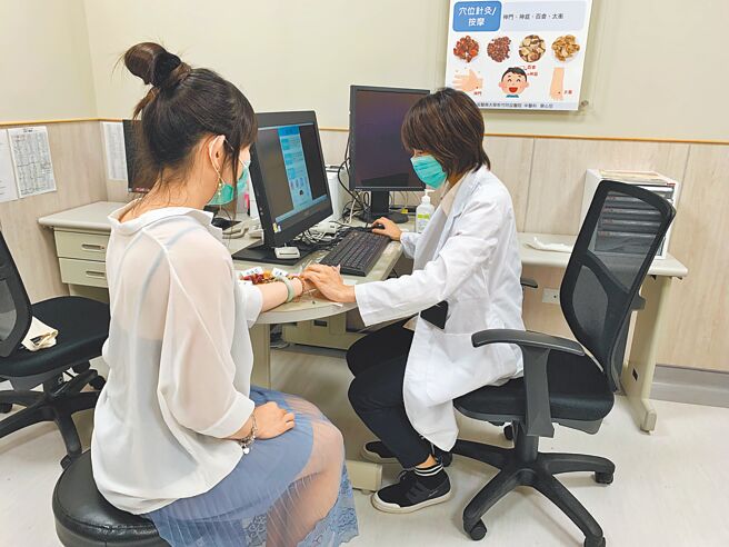中医师周书玉（右）透过诊断，协助患者改善失眠问题。（庄旻静摄）