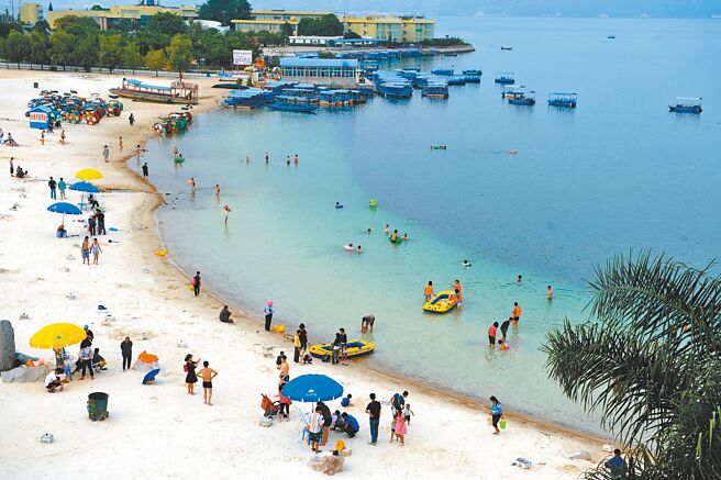 7月以来，大陆各地频发高温预警，避暑纳凉成为眾多游客暑期的首选，气温常年在20多度的云南机票预订量较上月增长一倍。图为游客在云南玉溪市的抚仙湖阳光海岸沙滩戏水玩耍。（新华社资料照片）