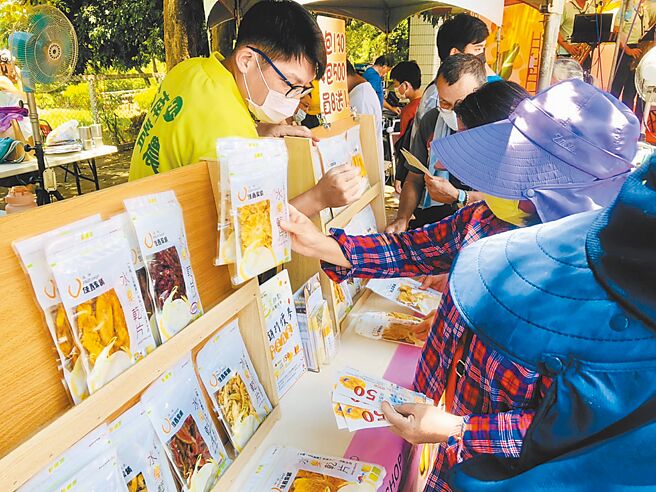 台南国际芒果节「玉井甜点踩点」活动23日登场，游客拿着50元折价券到摊位消费。（台南市政府农业局提供／张毓翎台南传真）