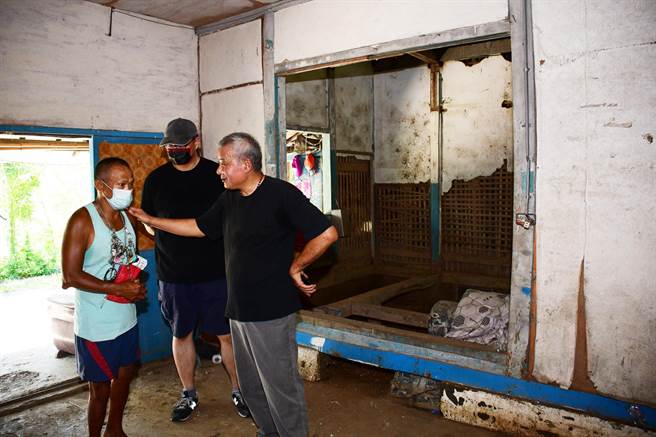 第1代红叶少棒教练邱庆成的遗孤邱敏福（左）向黑金城（右）介绍他家徒四壁，非常简陋的老家。（庄哲权）