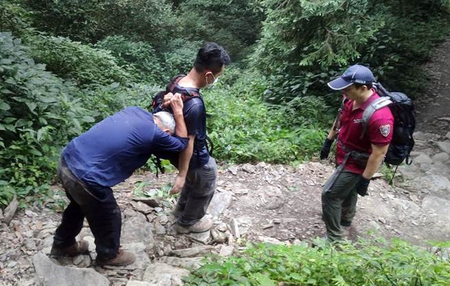陳姓山友遭領隊遺留在北大武山三角點，警消以背拉方式協助下山。（屏縣消防局提供／林和生屏東傳真）