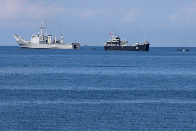 汉光38号演习28日上午在屏东加禄堂海边演练联合登陆作战，陆战旅、海、空军编成联合两栖特遣部队，採攻击军态势实施两栖突击作战，陆战队官兵搭乘AAV7两栖突击车驶出中平号（233，左）军舰，准备登陆突击，曾为美军战车登陆舰的中启舰（218，右）也参与演习。（黄子明摄）